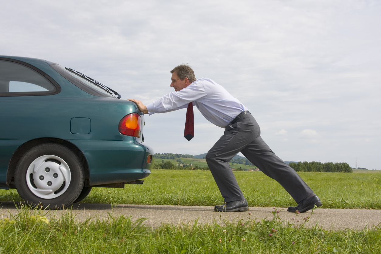 man pushing car